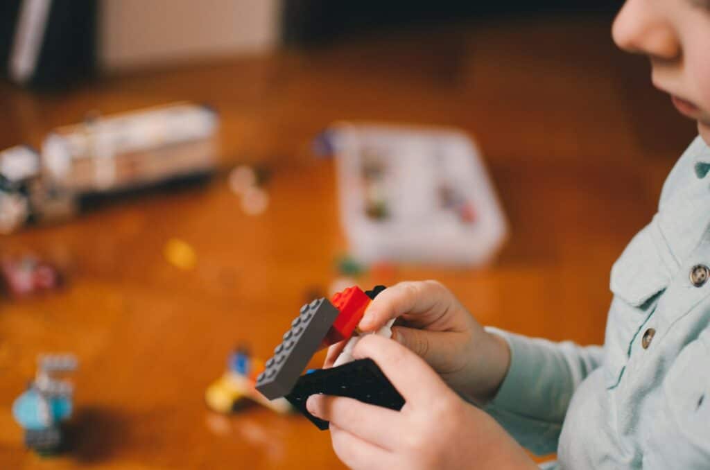 kid working on putting blocks together, focusing