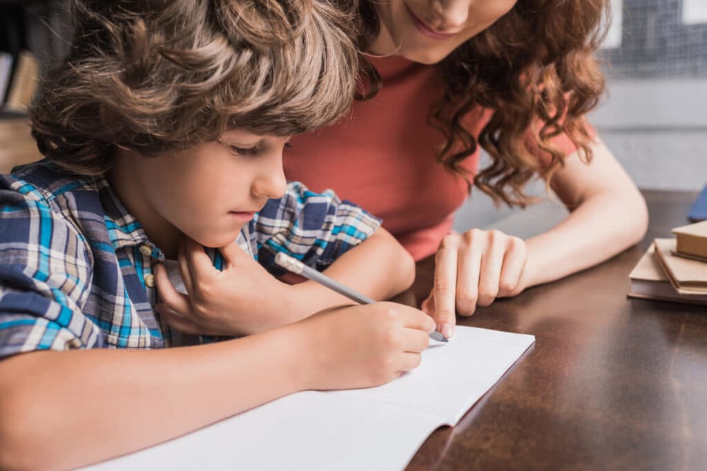 kid working on homework with his mother
