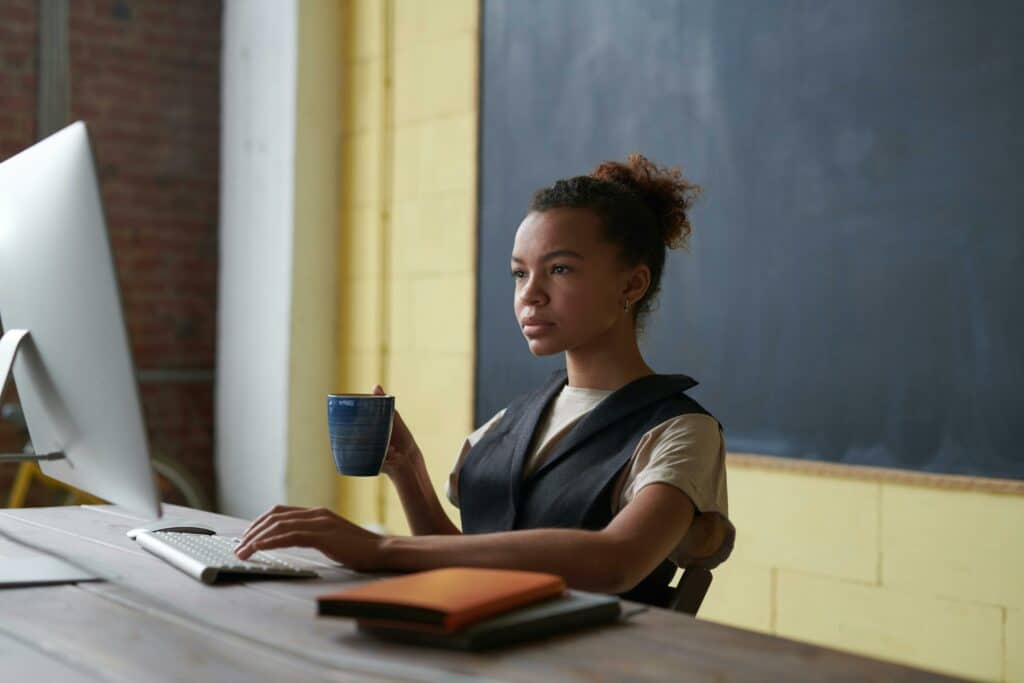 teacher sitting at desk drinking coffee