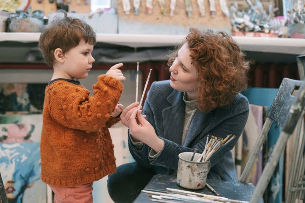 teacher listening to young boy in orange sweater talking
