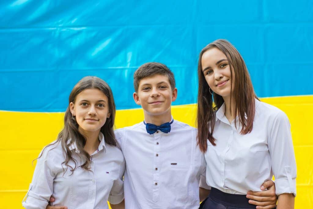 group of three teens standing together looking happy