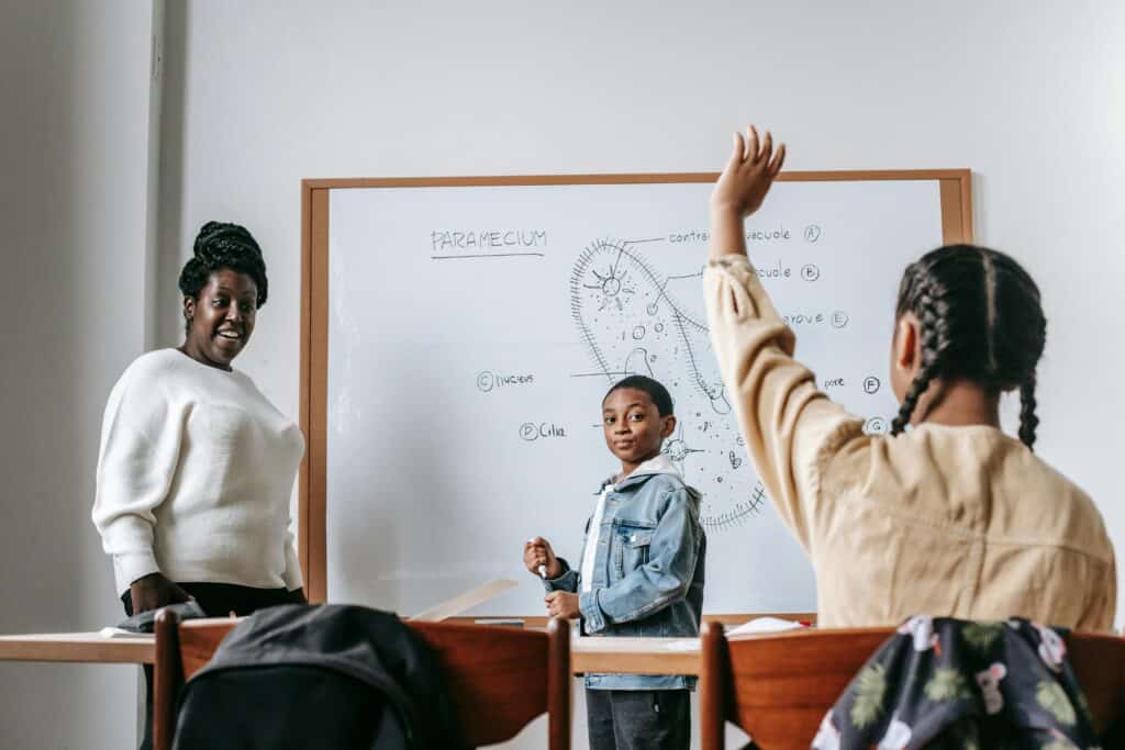 kid raising their hand in a classroom