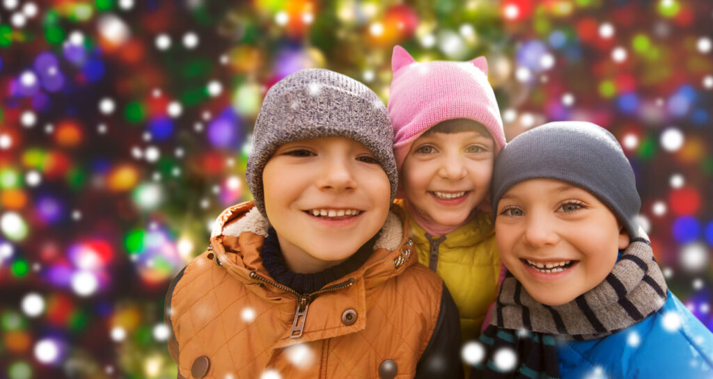 group of kids hugging over snow background and lights